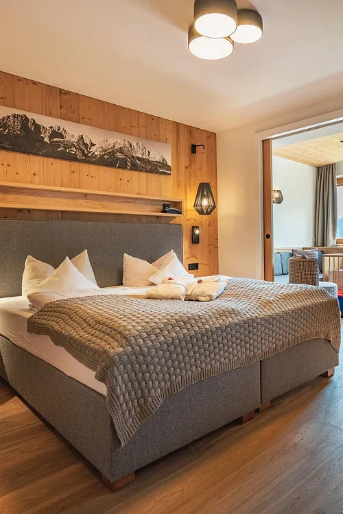 Gemütliches Doppelzimmer mit Holzwand und stimmungsvollem Licht
